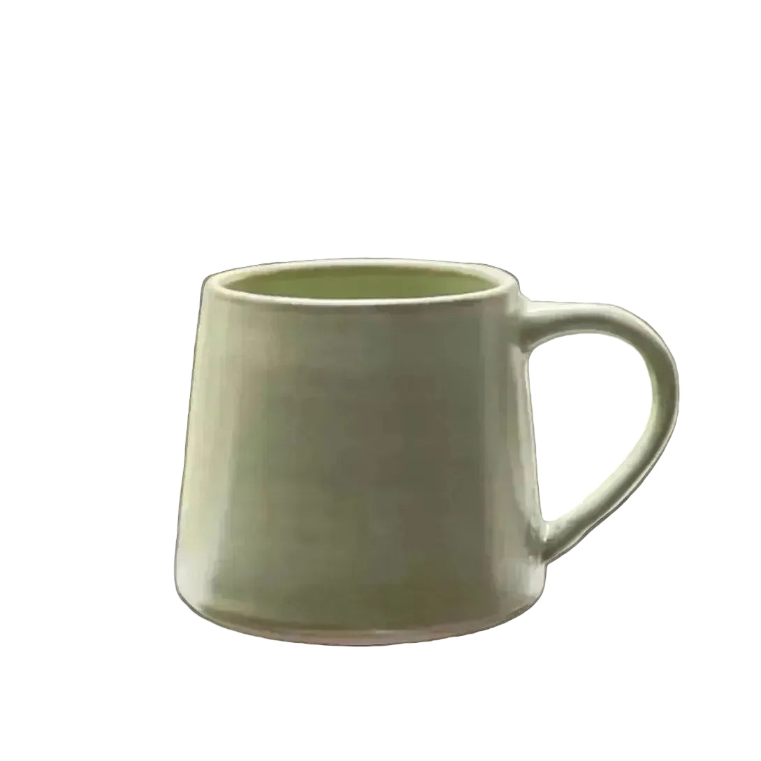 A light green coffee cup with tapered walls and a rounded handle. Cup opening is narrower than the base, creating angled walls. 

Glaze details: light lime green glaze with bown variations where the glaze is thiner, such as on the rim. 